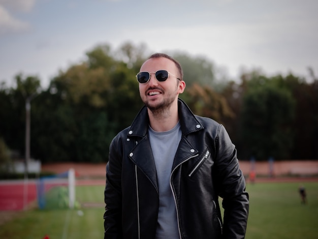 Hombre con chaqueta de cuero y gafas de sol se ríe