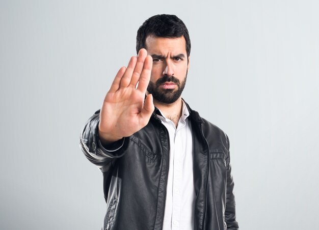 Hombre con chaqueta de cuero haciendo señal de stop