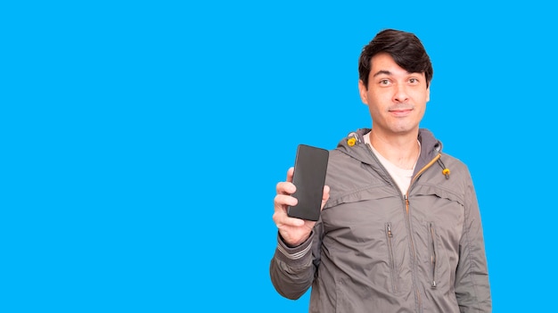 Foto hombre con chaqueta y sosteniendo un teléfono celular. mostrando la pantalla del teléfono inteligente,