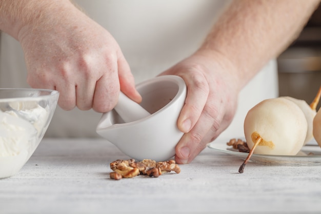 Hombre chef irreconocible moliendo especias en mortero y mortero para preparar condimentos