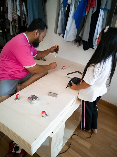 Foto hombre con chica en la mesa de reparación