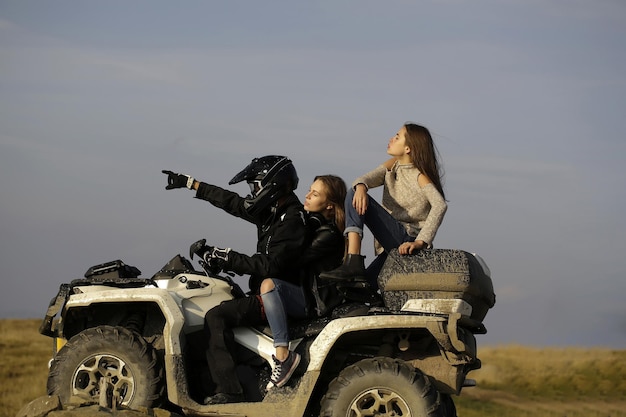 Hombre y chicas viajan en quad