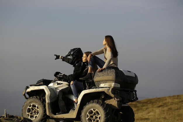 Hombre y chicas viajan en quad