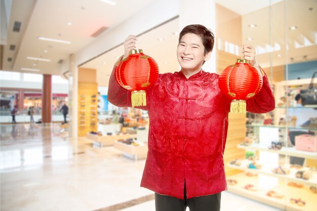 Un hombre chino asiático en un vestido cheongsam con linterna china