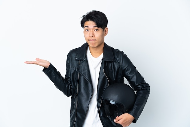 Hombre chino con un casco de moto en blanco con dudas mientras levanta las manos