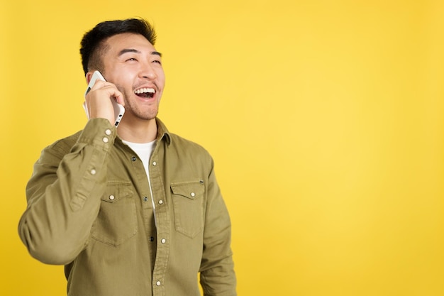 Hombre chino feliz hablando con el móvil