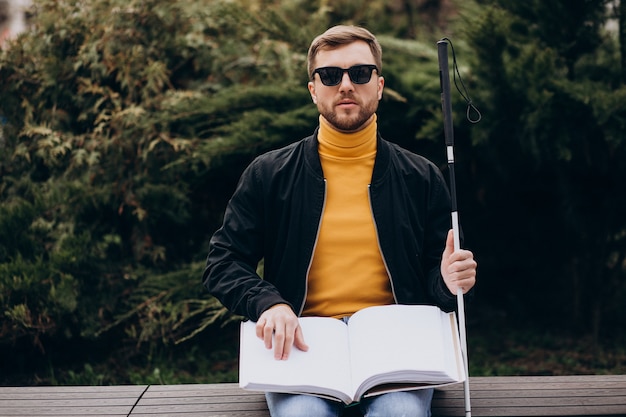 Hombre ciego leyendo tocando el libro en braille