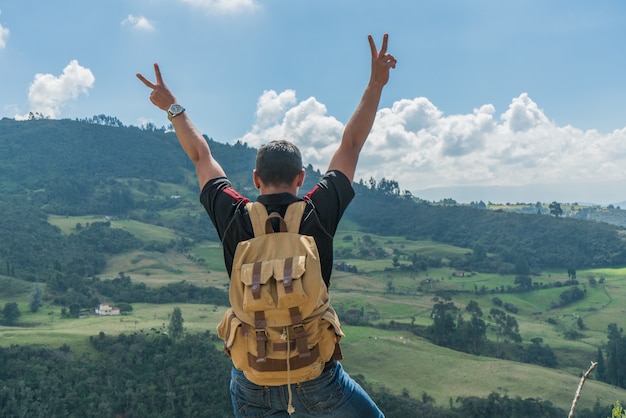 Hombre en la cima de una montaña con las manos en alto