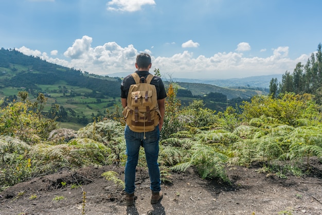 Hombre en la cima de una montaña con las manos en alto