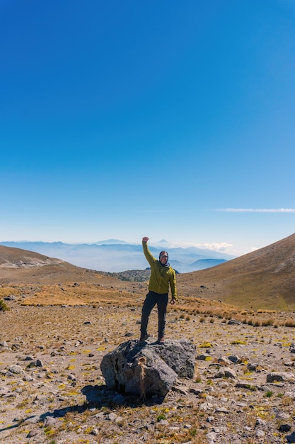 Hombre en la cima de una montaña rocosa