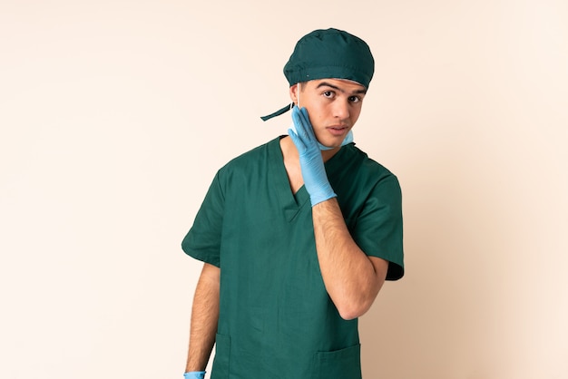 Hombre cirujano en uniforme azul sobre la pared susurrando algo