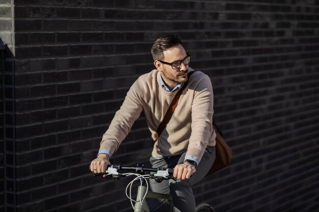 Un hombre de la ciudad andando en bicicleta en la calle.