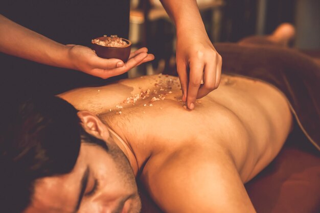 Hombre cliente teniendo tratamiento de exfoliación en spa de lujo quiescente