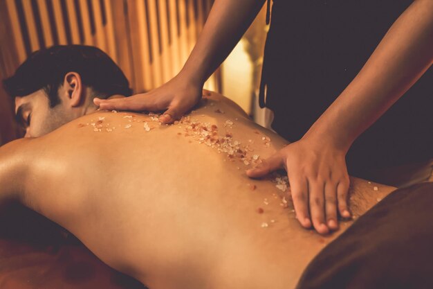 Hombre cliente teniendo tratamiento de exfoliación en spa de lujo tranquilo