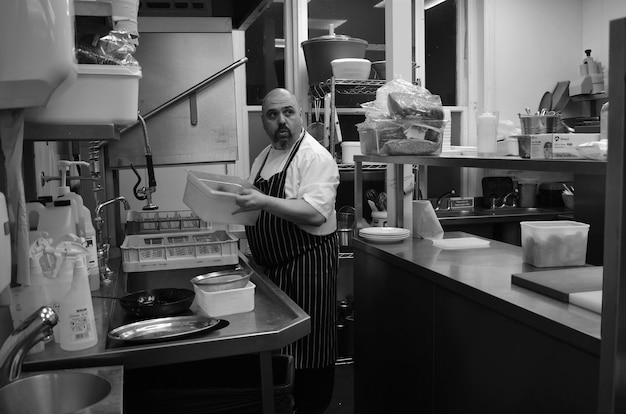 Un hombre en una cocina con un papel en la mano.