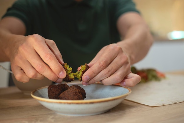 Hombre cocinando una comida casera de falafel