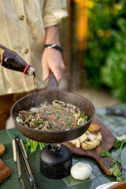 Hombre cocinando comida saludable al aire libre