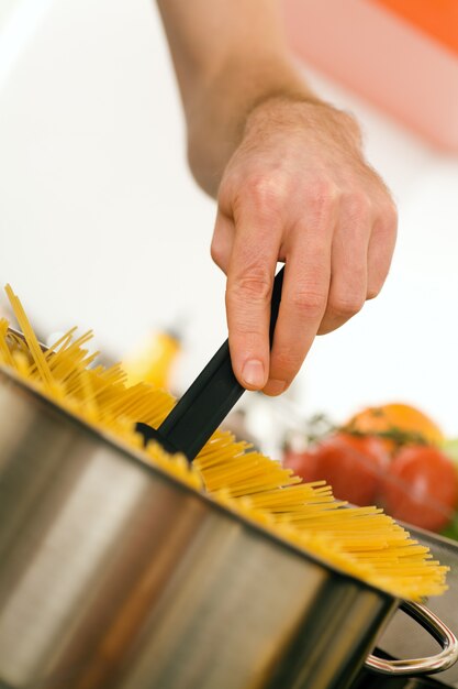 hombre cocinando pasta