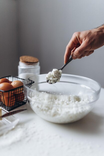 Foto un hombre cocinando un postre casero con productos lácteos.