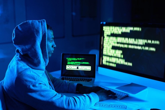 Hombre de código o hacker en la pantalla de tecnología para cibercrimen malware o phishing para robar datos en línea Programador oscuro o escribir actualización de software en la computadora para hackear o robar en el sitio web en la noche