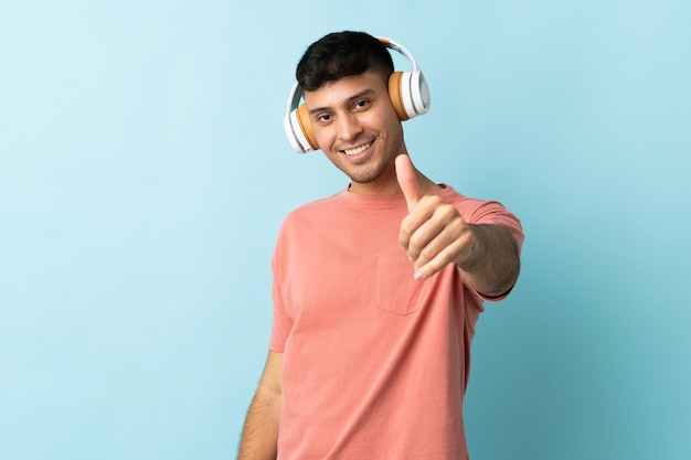 Hombre colombiano escuchando música y con el pulgar hacia arriba