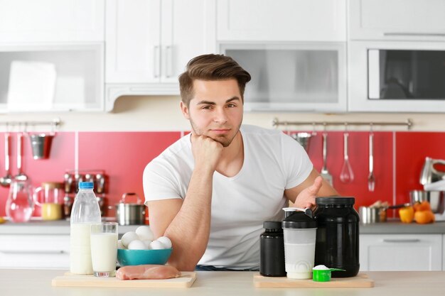 Hombre con comida saludable y nutrición deportiva en la cocina.