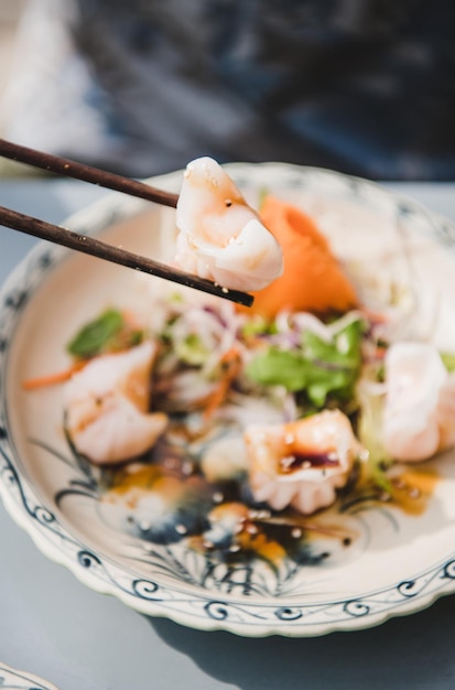 Hombre comiendo albóndigas Dim Sum vietnamita con palillos