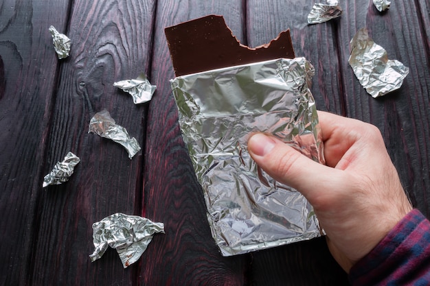 Hombre comiendo una barra de chocolate negro