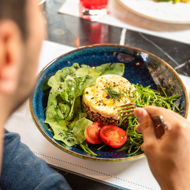 Hombre comiendo una ensalada fresca y sabrosa