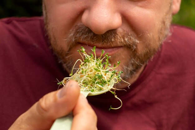 Hombre comiendo semillas germinadas con una cuchara