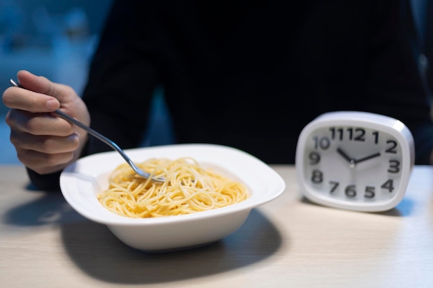 Foto hombre comiendo tarde en la noche solo en la escena de casa o apartamento