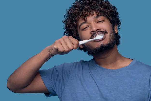 Hombre complacido con un cepillo de dientes durante el procedimiento de cepillado de dientes