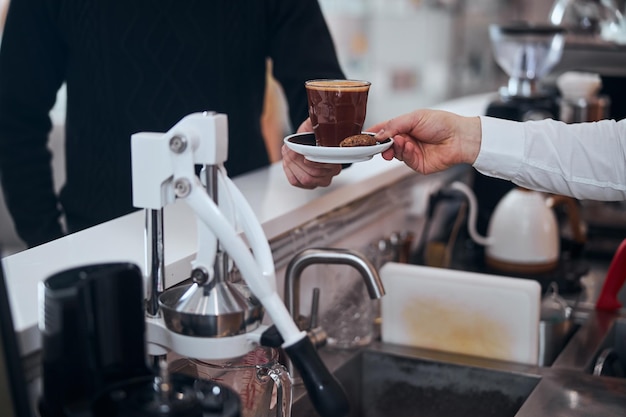 Hombre comprando bebida caliente en el bar de la cafetería