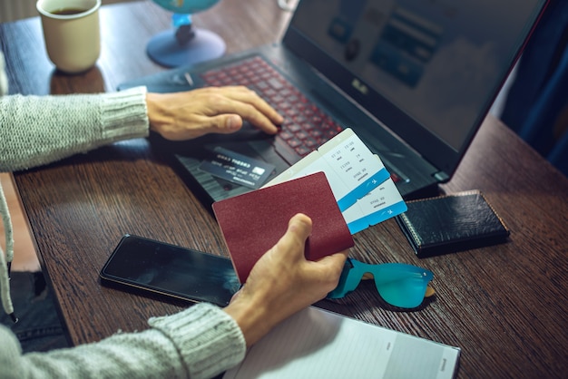 Un hombre está comprando boletos aéreos a través de internet usando una computadora portátil para un viaje tan esperado