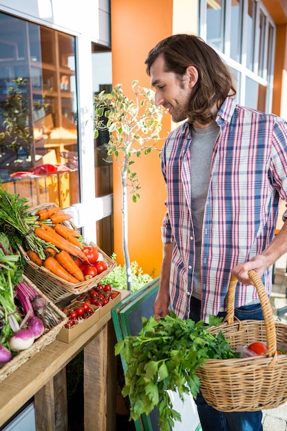 Hombre comprando verduras en tienda ecológica