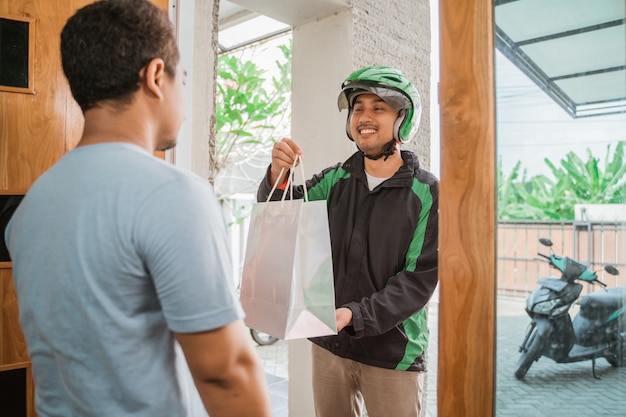 Foto hombre de compras en línea y entregado