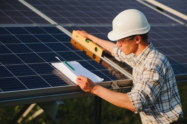 Hombre comprobando y parado cerca de paneles solares