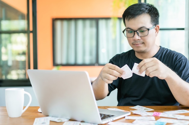 Hombre comprobando los resultados de la lotería en la computadora portátil y perdiendo