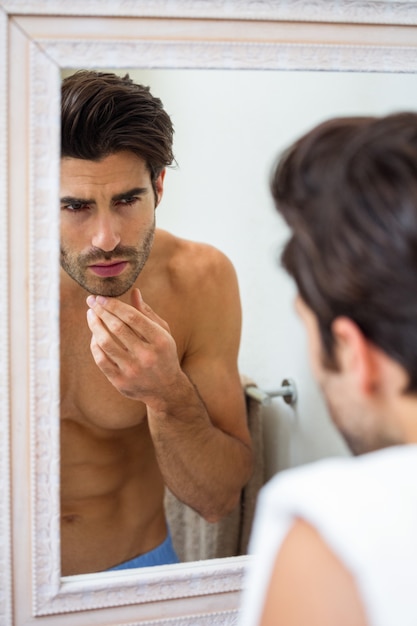 Hombre comprobando su rastrojo en el baño.