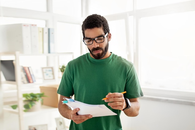 Foto hombre concentrado con gafas y barba con una camiseta verde