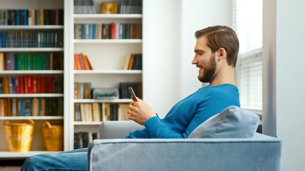 El hombre concentrado mira al teléfono inteligente