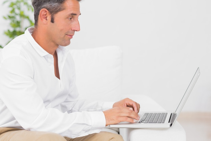 Foto hombre concentrado usando su computadora portátil