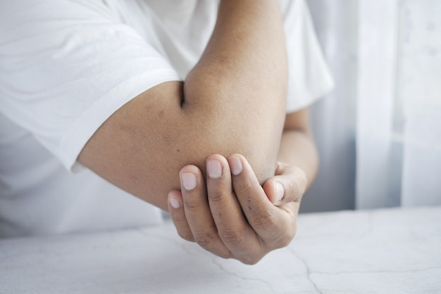 Hombre con concepto de alivio del dolor de dolor de codo