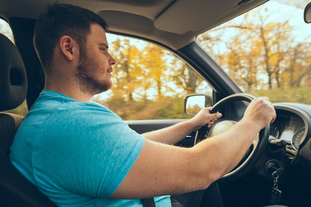 El hombre del concepto de viaje por carretera pone las manos en la navegación del volante en el teléfono