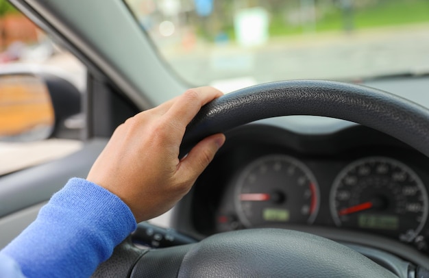 Un hombre conduce un coche con volante.