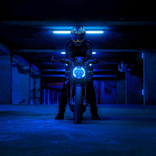 Foto un hombre conduce una motocicleta con una luz de neón.