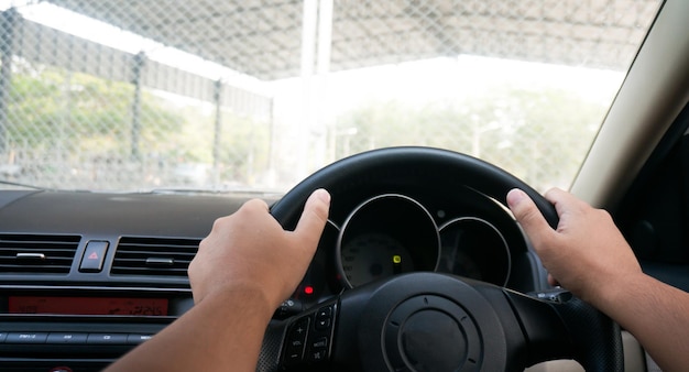 Foto hombre conduciendo con ambas manos en el volante enfoque selectivo coche de conducción de seguridad