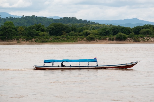 Un hombre conduciendo un bote de cola larga en el río MEKHONG