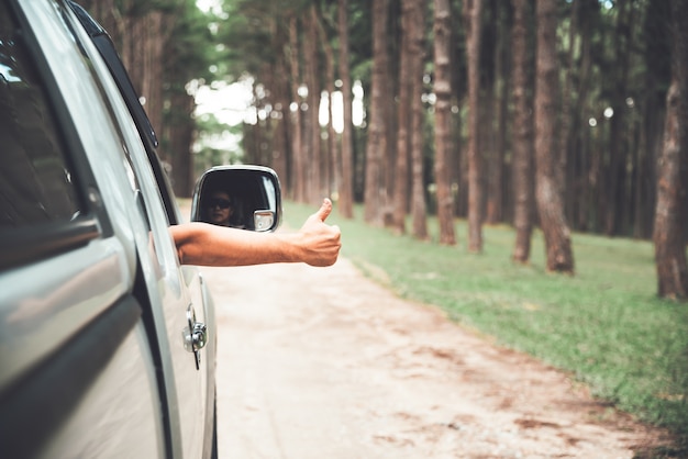 Un hombre conduciendo una camioneta, estirando la mano del automóvil Excelente símbolo