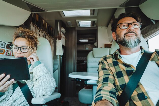 Foto hombre conduciendo camper sonríe mientras conduce con su esposa compañía concepto de vacaciones de viaje y vida juntos